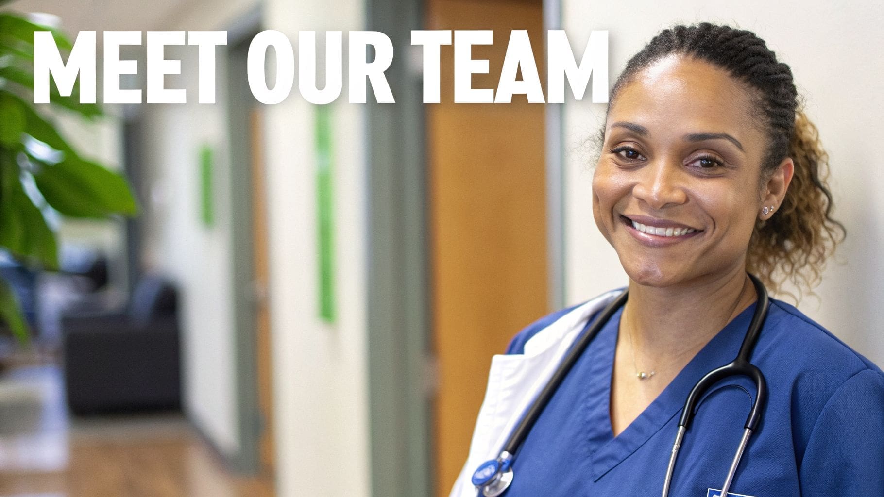 A smiling female healthcare professional in blue scrubs with a stethoscope, standing in a clinic.